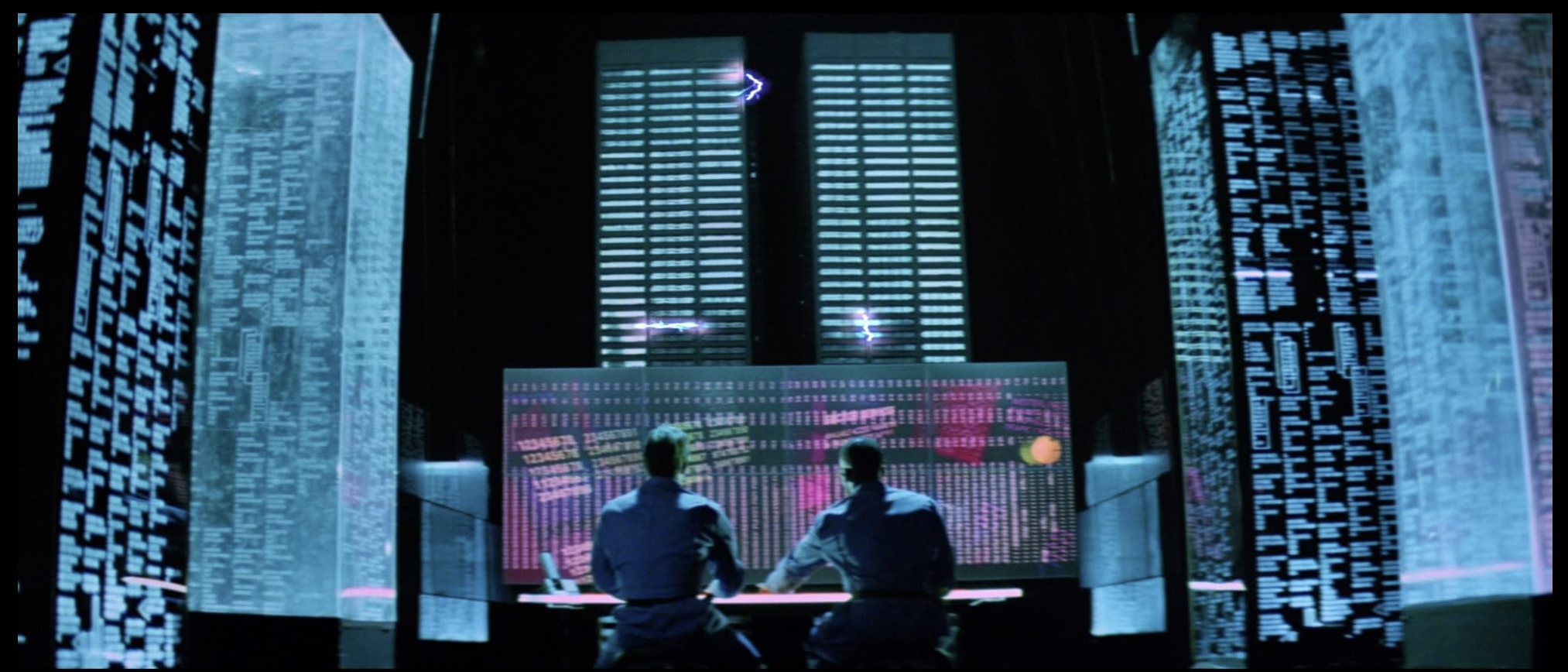 Scene from Hackers (1995) showing characters surrounded by data screens