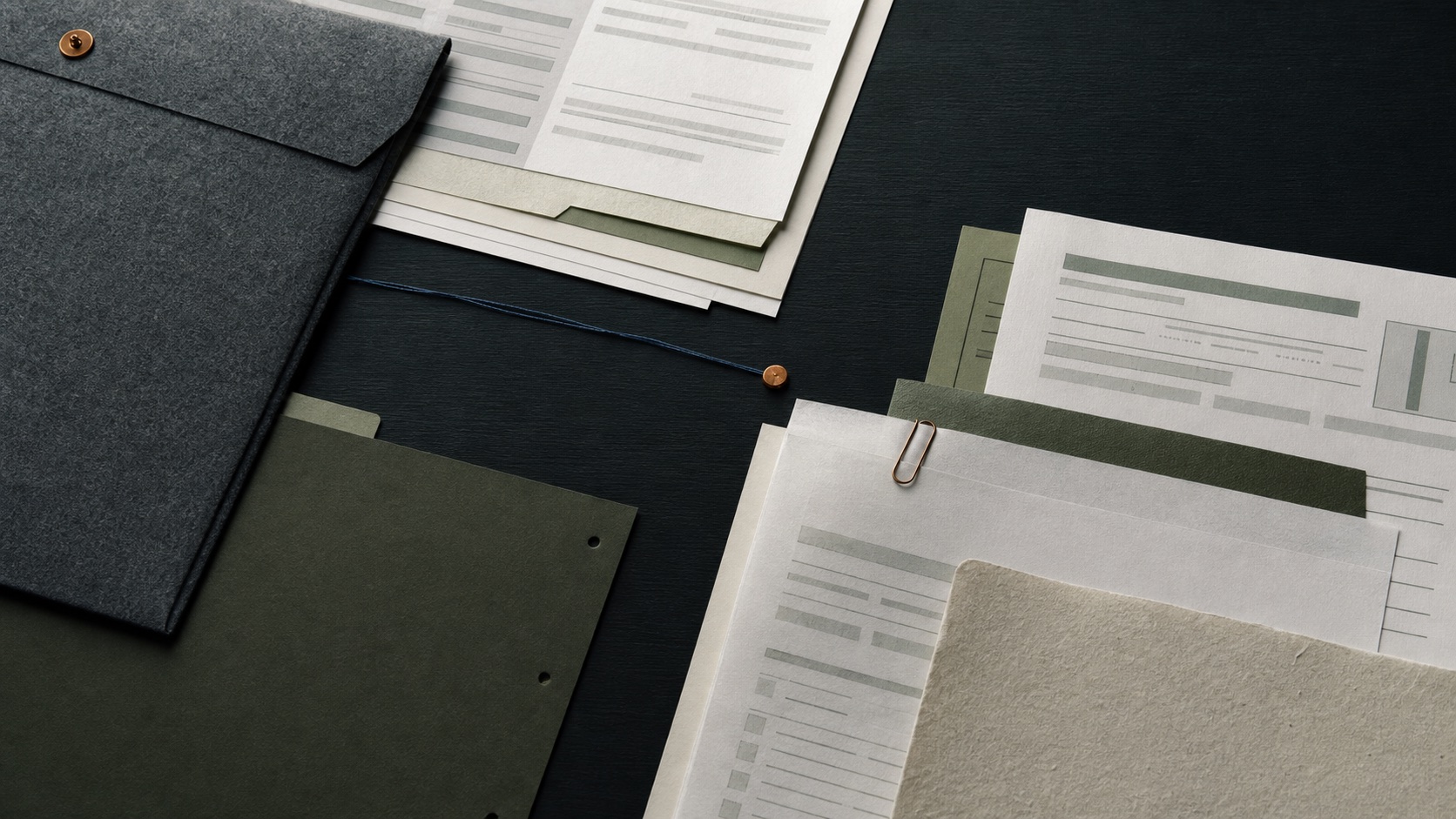 Layered administrative documents arranged across a dark work surface
